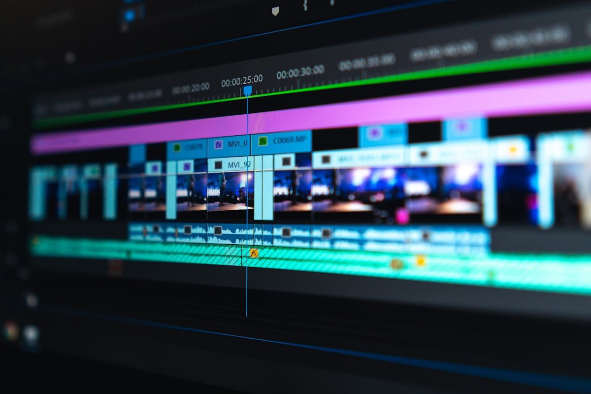 Digital Content Creators: Video editing timeline and audio mixing waveforms on dual 4K monitors in studio